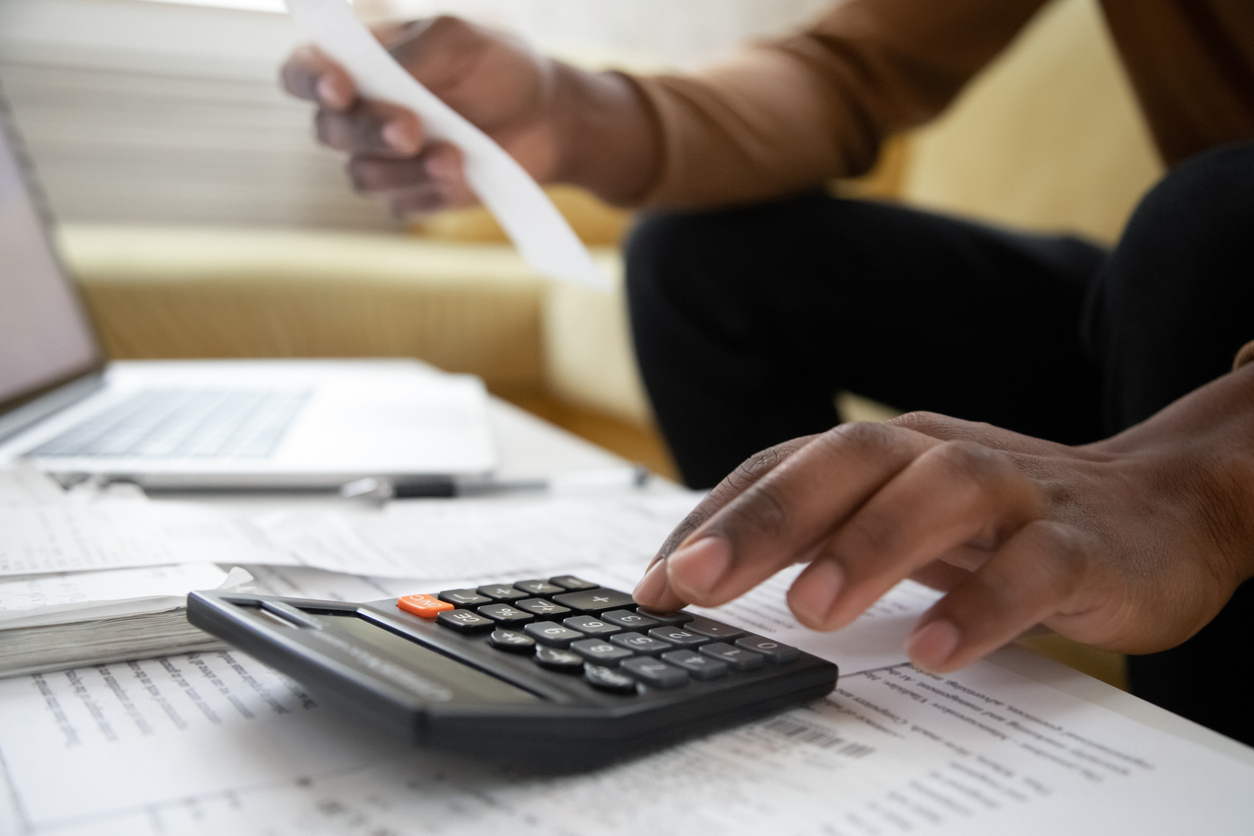 Person calculating monthly housing costs on a calculator while budgeting for an apartment near Nashville TN